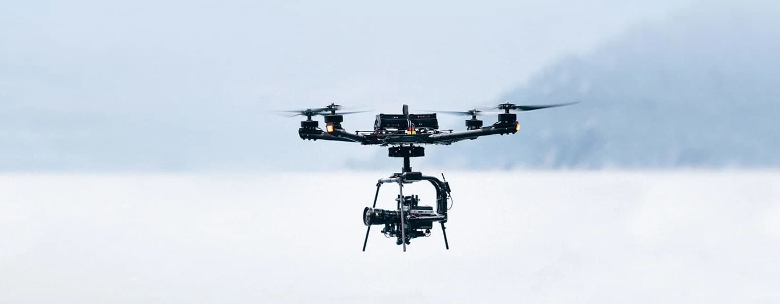 A cinelifter drone flying over a dramatic canyon.